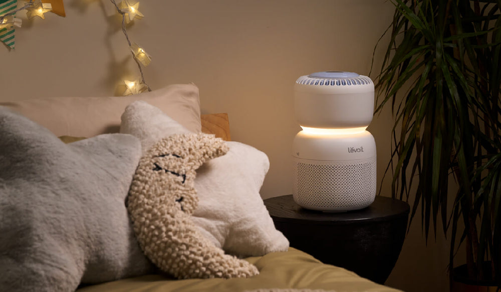 Compact white HEPA air purifier on a wooden desk in a dorm or bedroom setting