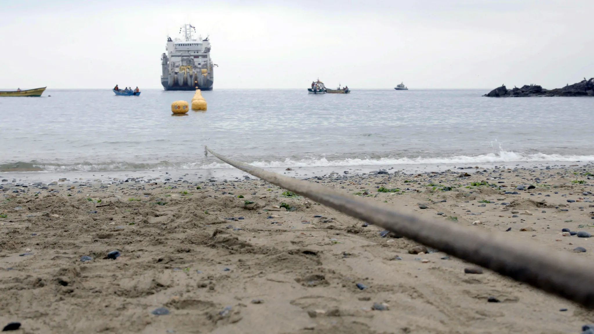 Submarine fiber-optic cable being pulled ashore during a landing operation