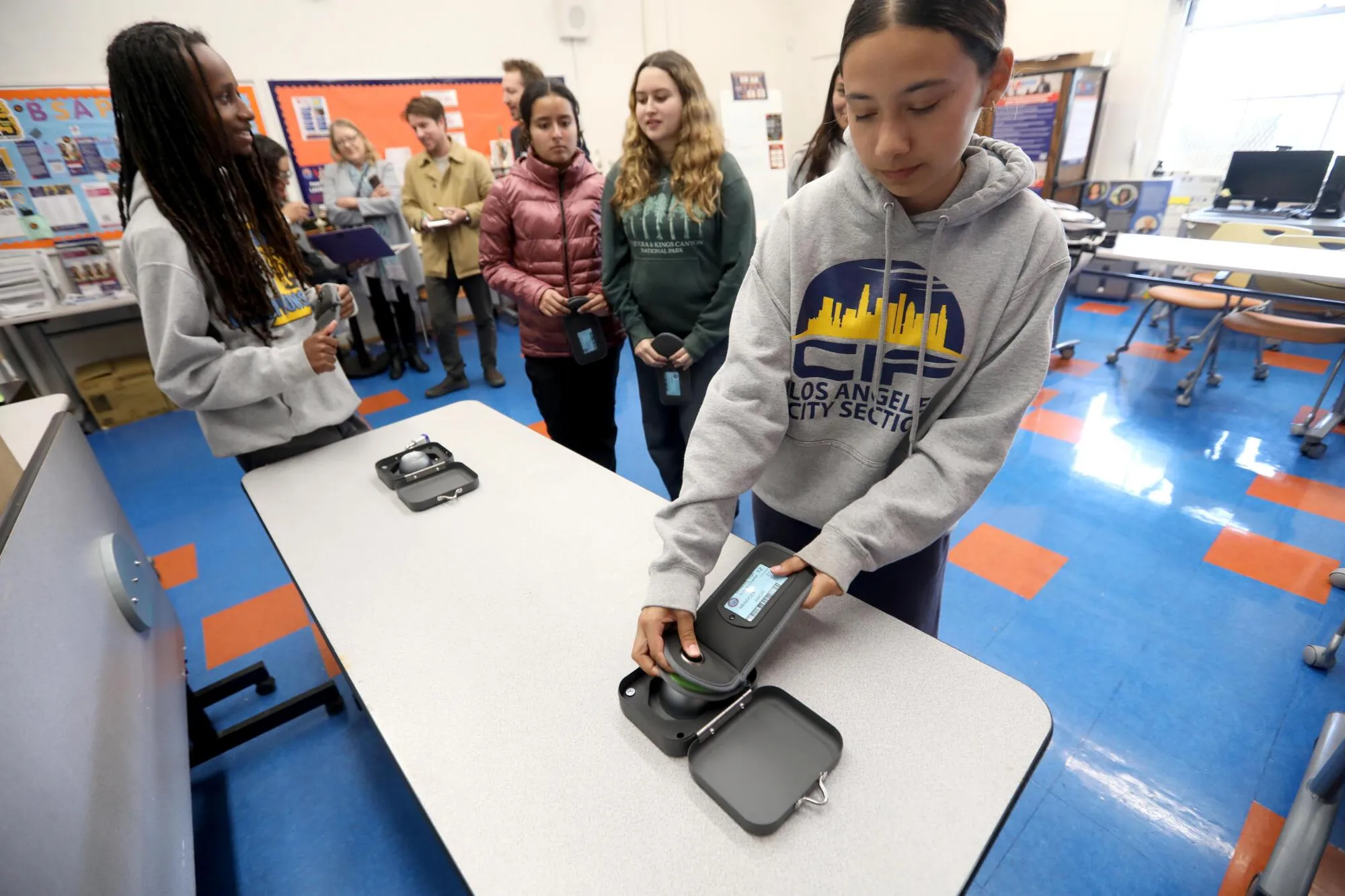 Students' phones stored in gray lockable school phone pouches